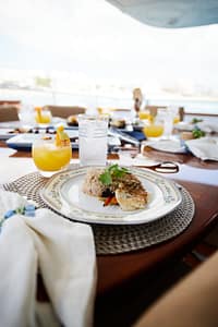 A chef-prepared gourmet meal of grilled seafood and fresh vegetables on a luxury Cabo yacht charter.