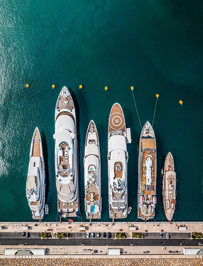 An aerial view of luxury yachts docked in a marina in Los Cabos, showcasing their grandeur from above.